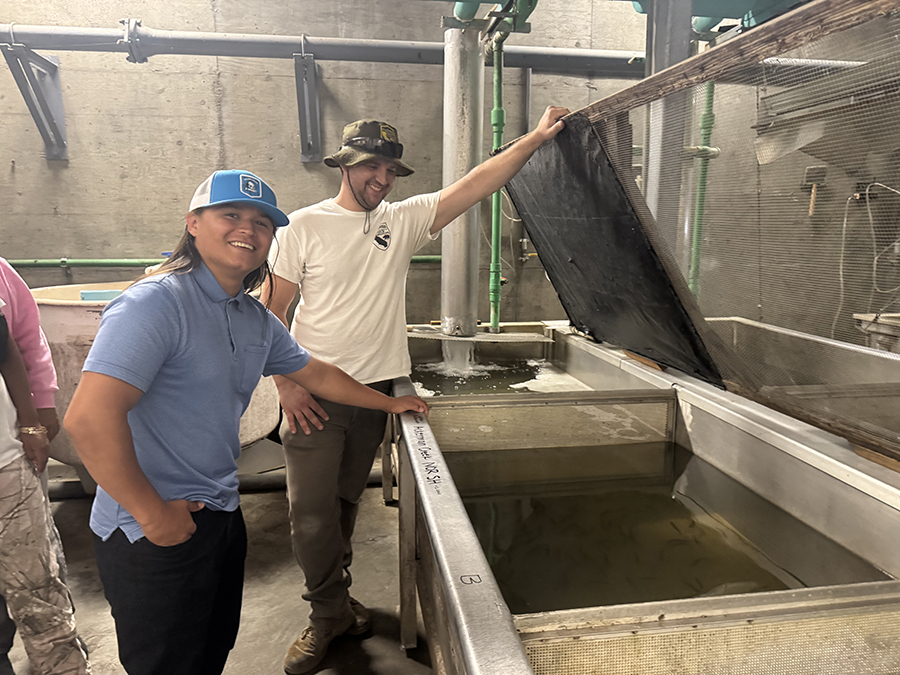 Two people at hatchery tank. CDFW photo
